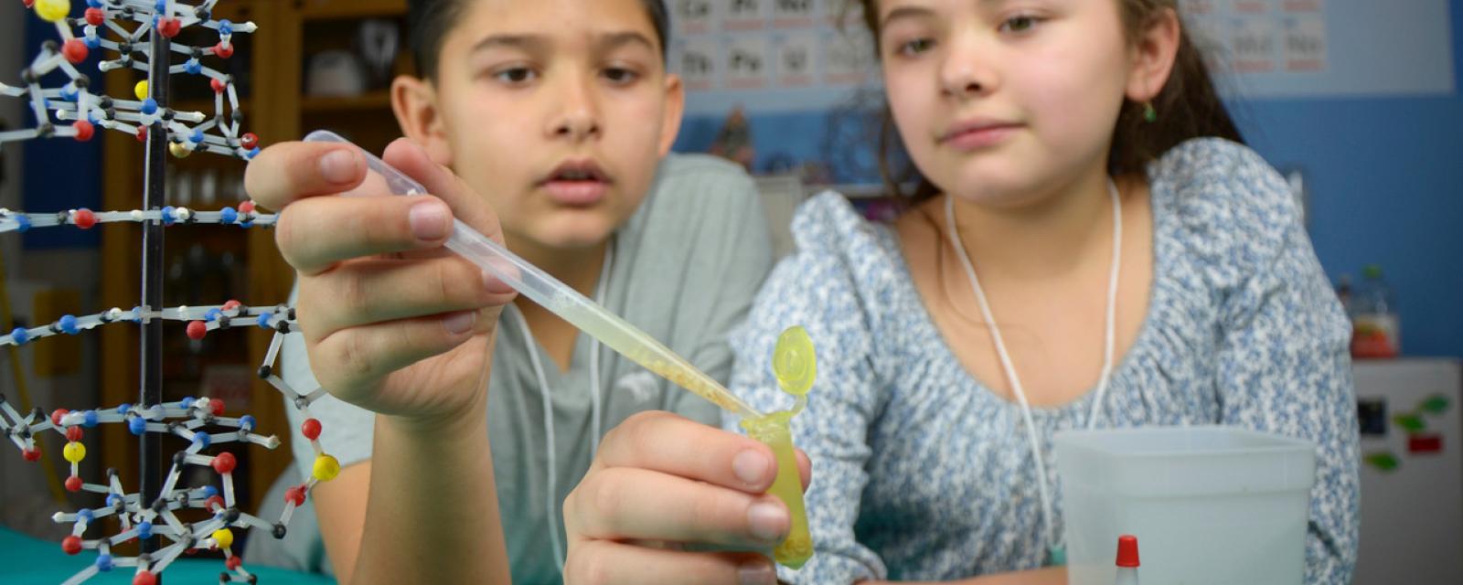 Two children extracting visible DNA from wheat germ in Building with Biology kit