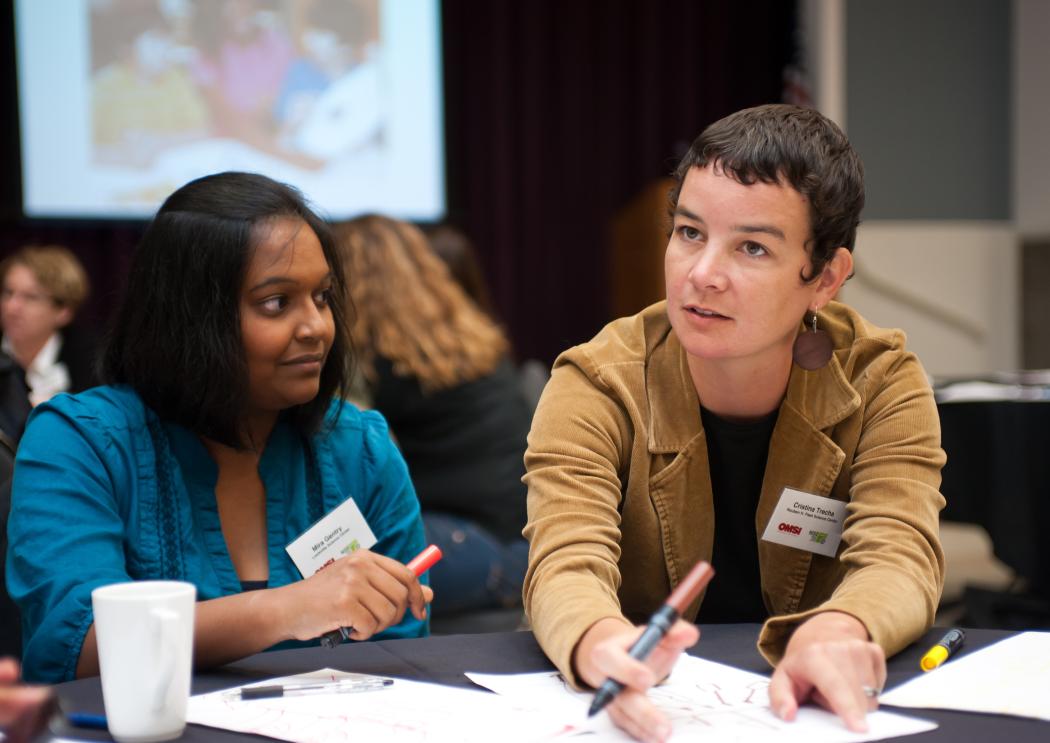 Two professionals at a meeting gesturing